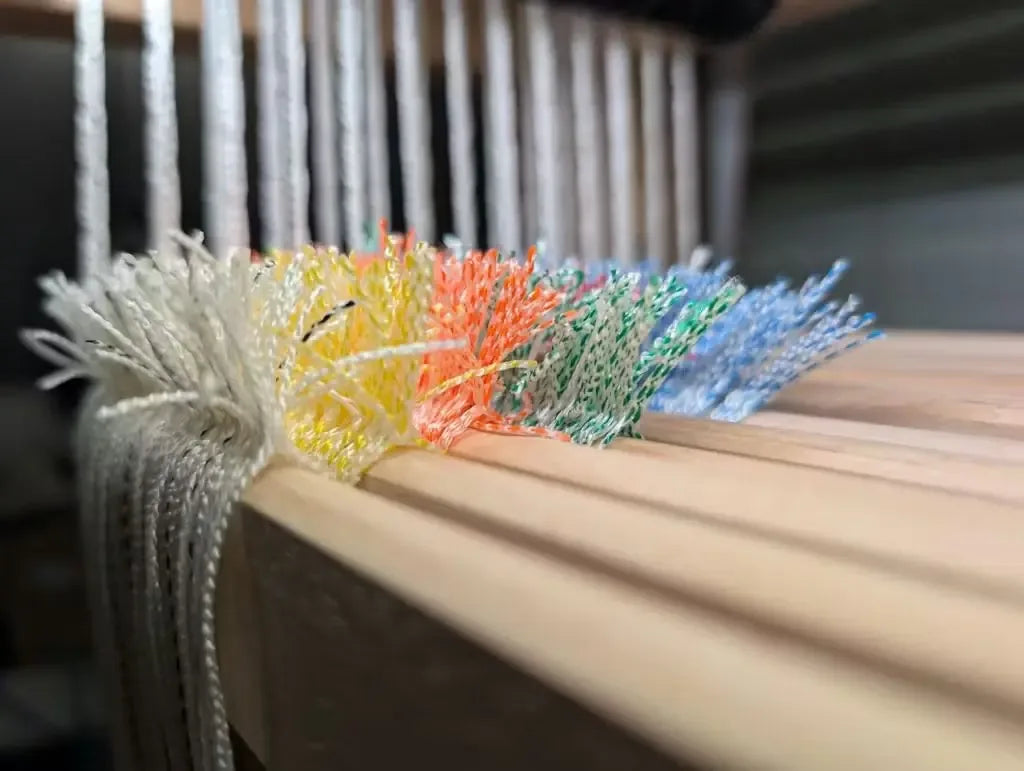 Coloured Texsolv heddles on the shafts of a loom